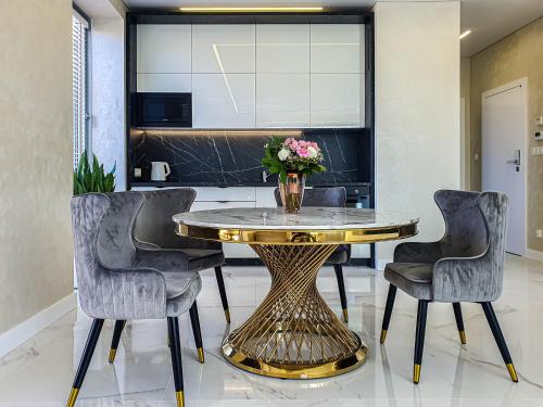 jadalnia ze złotym stołem i 2 krzesłami w obiekcie Apartament Faltom 20 Yacht Park Premium w mieście Gdynia