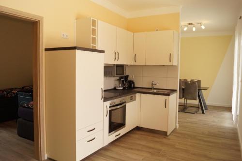 a kitchen with white cabinets and a stove top oven at Seeoase Lychen in Lychen