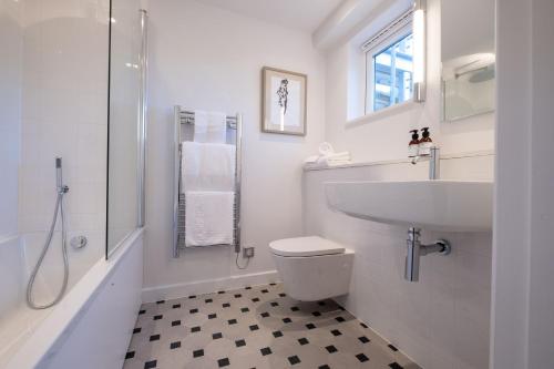 a white bathroom with a sink and a toilet at Hotel Meudon in Falmouth