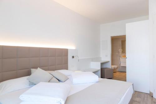 a white bed with white pillows in a bedroom at Gabbiano in Malcesine
