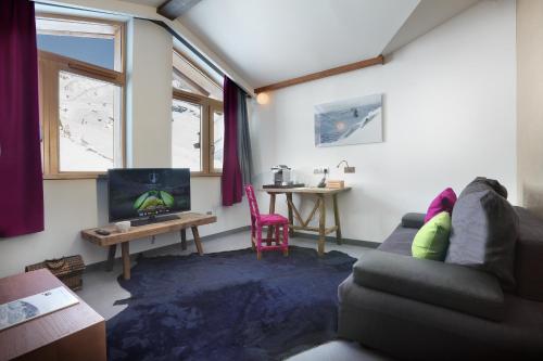 a living room with a couch and a table at Hotel Pashmina Le Refuge in Val Thorens