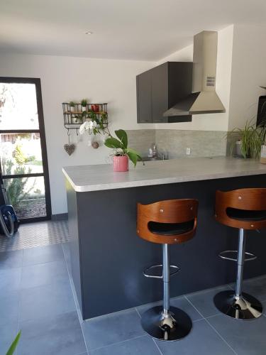 une cuisine avec un comptoir et deux tabourets de bar dans l'établissement LA GRIOTTE 3 LOFT & Spa, à Pennedepie