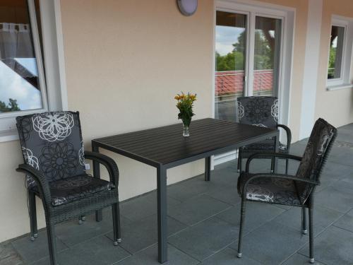a table and chairs with a vase of flowers on it at Seeoase Lychen in Lychen