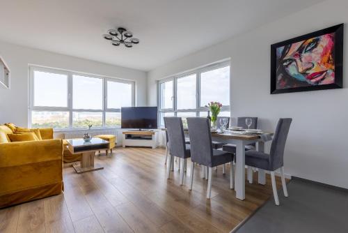 a living room with a table and chairs and a couch at Symphony Baltica Towers Apartamenty in Gdańsk