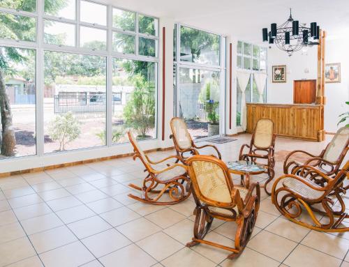 a room with rocking chairs and windows at Hotel La Estacion in Granada