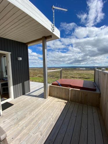 a wooden deck with a bed on it at Blue View Cabin 3B With private hot tub in Reykholt