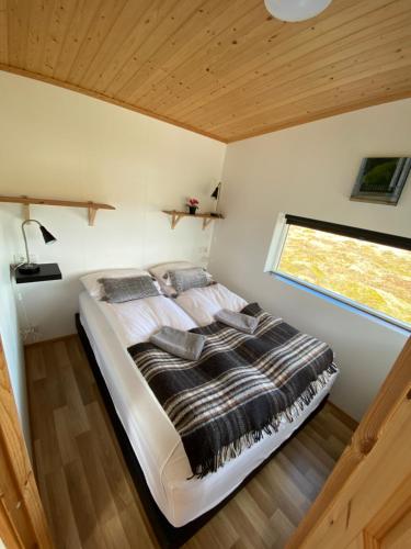 a large bed in a room with a window at Blue View Cabin 3B With private hot tub in Reykholt