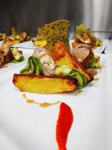 a white plate of food with vegetables and sauce at Hotel Frigopan in Plovdiv