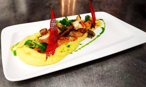 a white plate with a dish of food on a table at Hotel Frigopan in Plovdiv