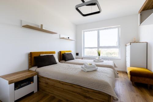 a bedroom with two beds and a refrigerator at Symphony Baltica Towers Apartamenty in Gdańsk