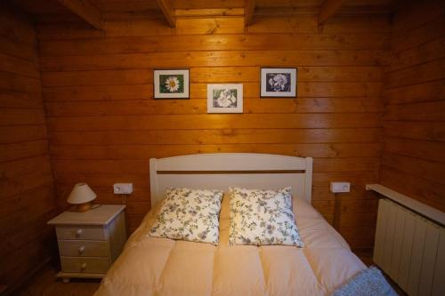 sypialnia z łóżkiem i 2 zdjęciami na ścianie w obiekcie Bungalow Tossa Pelada i Mobil Home Rodell w mieście Fornols