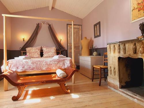 ein Schlafzimmer mit einem Bett und einem Kamin in der Unterkunft Le Clos des pins in Claira