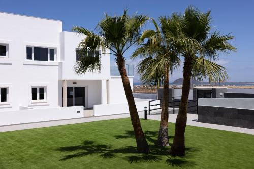 two palm trees in front of a white house at Island Home Fuerteventura in Corralejo