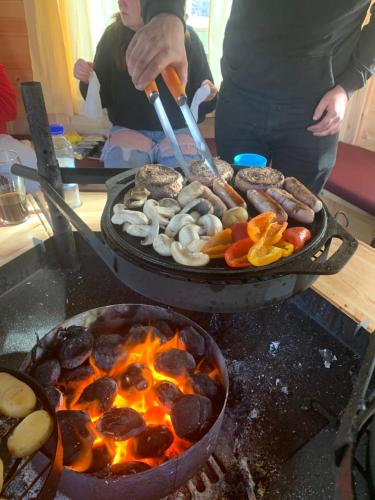 a person is cooking food on a grill at Daviot Luxury Pods in Inverness