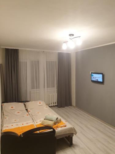 a bedroom with a bed and a tv on the wall at Квартира на бульваре Вечернем in Kryvyi Rih