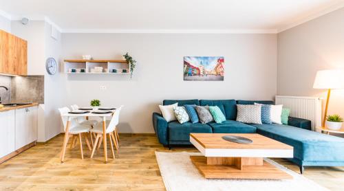 a living room with a blue couch and a table at Apartamenty Homely Place Blisko Starego Rynku - Parking in Poznań