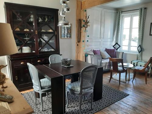 La maison de la baie, wifi, terrasse, 200m du port في سانت فاليري سور سوم: غرفة معيشة مع طاولة طعام وكراسي