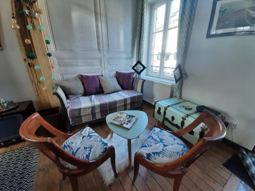 La maison de la baie, wifi, terrasse, 200m du port في سانت فاليري سور سوم: غرفة معيشة مع أريكة وكرسيين وطاولة