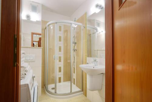 ein Bad mit einer Dusche und einem Waschbecken in der Unterkunft Apartment Sand Castle with free parking in Świnoujście