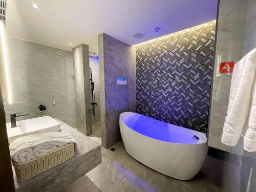 La salle de bains est pourvue d'une baignoire et d'un lavabo. dans l'établissement Fifth Avenue Motel, à Taichung
