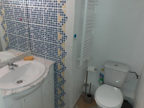 une salle de bain blanche avec un lavabo et des toilettes dans l'établissement Arena Résidence, au Cap d'Agde