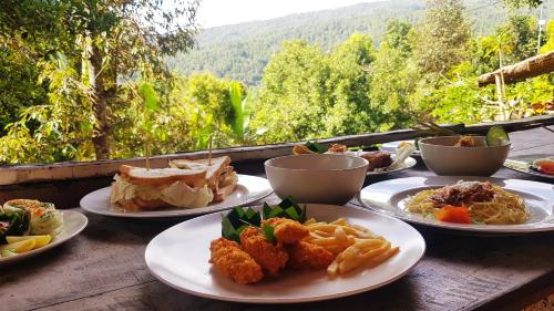 un tavolo di legno con piatti di cibo sopra di Swar Bali Lodge a Munduk