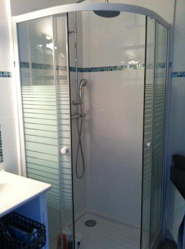 une douche avec une porte vitrée dans une salle de bain dans l'établissement VACANCES MER, à Saint-Cyr-sur-Mer