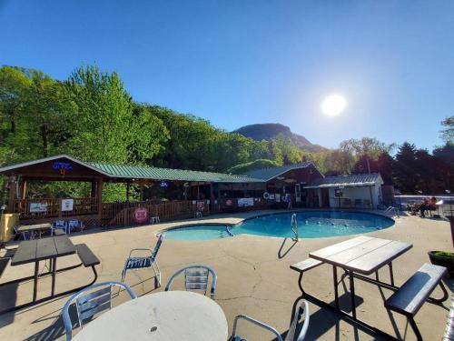 a swimming pool with tables and chairs and a building at Geneva Hotel & Tiki Bar in Lake Lure