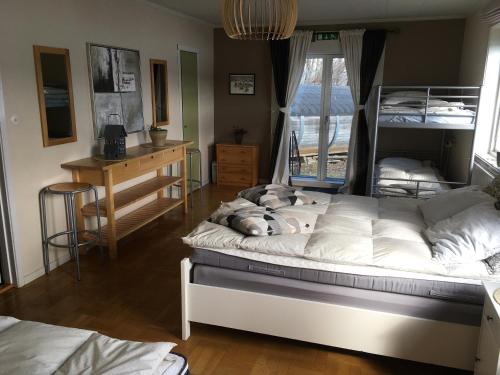 a bedroom with two beds and a desk and a window at Tärnaby Rooms & Apartments in Tärnaby