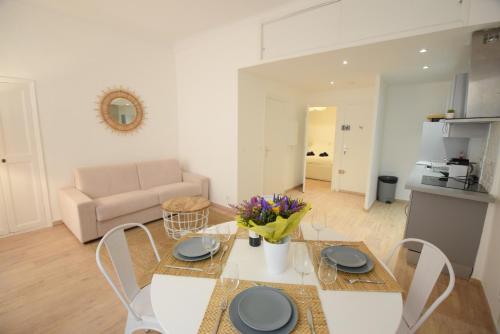 un salon avec une table, des chaises et un canapé dans l'établissement Nice Renting - BARILLERIE - COZY LOFT OLD NICE - SEA FRONT - SALEYA - MASSENA, à Nice