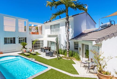 an image of a backyard with a swimming pool and a house at Morgen Guesthouse Somerset West in Somerset West