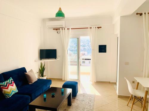a living room with a blue couch and a table at Villa Saral Mar in Sarandë