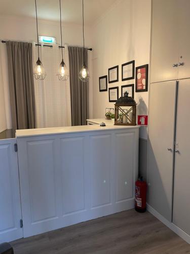 a kitchen with white cabinets and lights at Casa de Hospedes D. Maria Parreirinha in Sintra