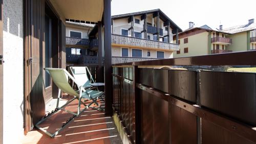 una sedia sul balcone di un edificio di Italianway - Sertorelli 2 a Bormio