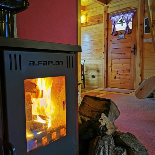 a fireplace in a bedroom with a bed and a room with a bed at Brvnara Tara in Bajina Bašta