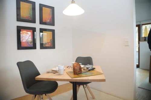 a dining room table with two chairs and a table with a plate at Alb Lodge in Gomadingen