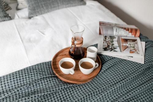 - un plateau avec 2 tasses de café sur le lit dans l'établissement ☆Reif für die Insel? Cozy Apartment auf Usedom, à Karlshagen