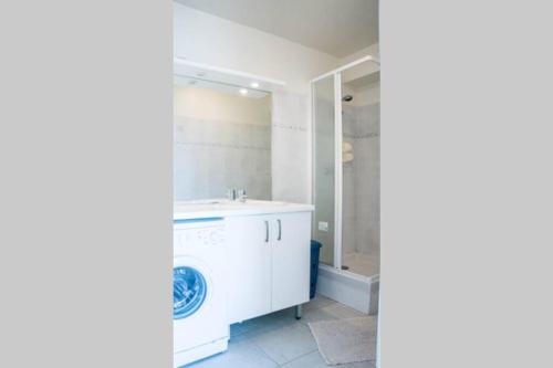 a bathroom with a washing machine and a sink at Les Galets de Cécile in Cayeux-sur-Mer