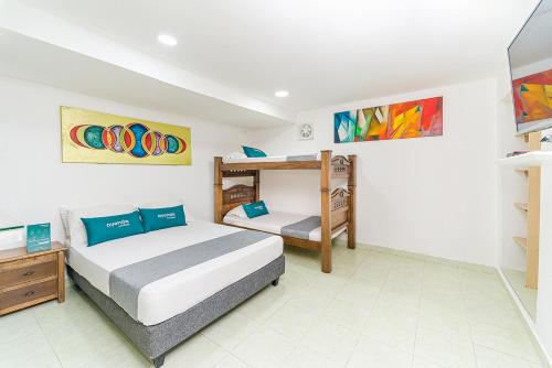 巴蘭基亞的住宿－Hotel Ayenda Casa Paraiso 1327，一间卧室配有两张床和一张双层床。