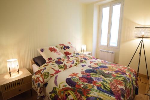 - une chambre avec un lit doté d'une couverture fleurie et d'une fenêtre dans l'établissement Nice Renting - PAIROLIERE - SPACIOUS FLAT - OLD NICE - MASSENA - TERRACE, à Nice