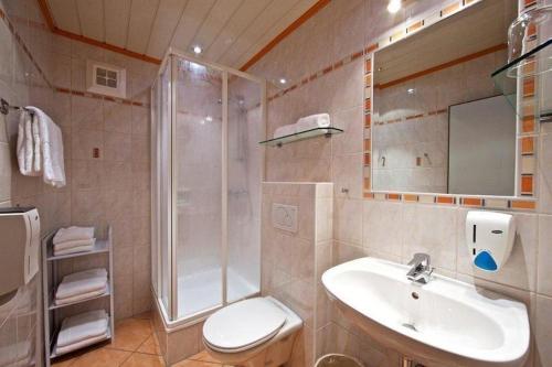 a bathroom with a shower and a toilet and a sink at Hotel Auszeit in Sankt Kanzian