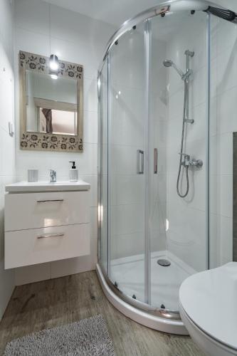 a white bathroom with a shower and a sink at Willa Wiesia Rabka Zdrój in Rabka-Zdrój