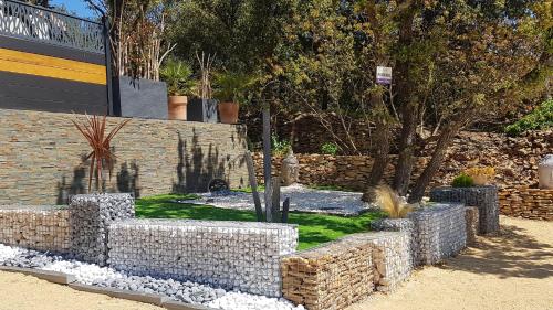 a garden with a stone wall and a tree at Charmante Maison avec jardin à Mornas in Mornas