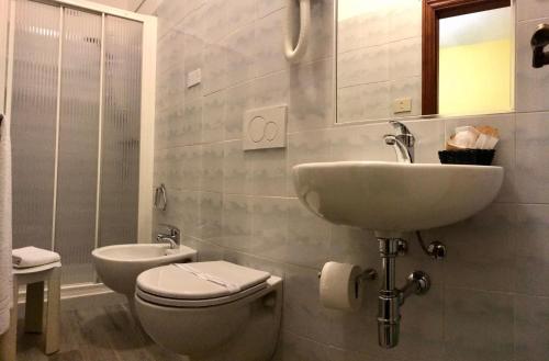 a white bathroom with a sink and a toilet at Albergo Ristorante Belvedere in Minucciano