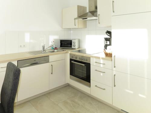 uma cozinha branca com um lavatório e um micro-ondas em Apartment Hanser - MHO752 by Interhome em Ramsau im Zillertal