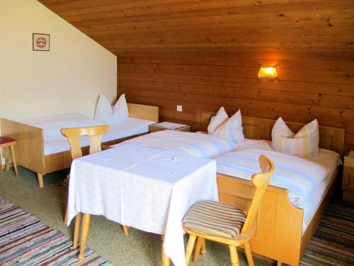 a hotel room with two beds and a table and chairs at Apartment Bauernhaus Schusterhäusl by Interhome in Schwendau