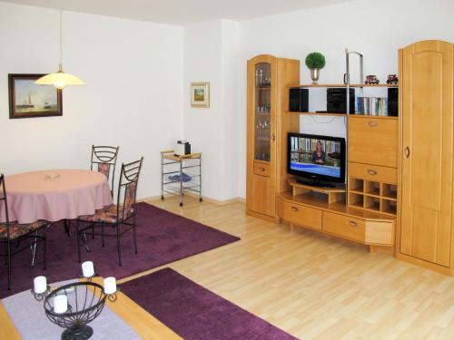 Apartment Glowe - GLW654 by Interhome في Klein Gelm: غرفة معيشة مع طاولة طعام وتلفزيون