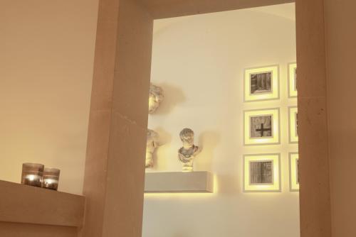 a white wall with some statues on a shelf at Palazzo Lecce - Epoca Collection in Lecce