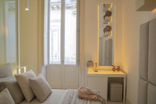 a living room with a bed and a mirror at Palazzo Lecce - Epoca Collection in Lecce