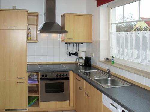 a kitchen with a sink and a stove at Apartment Gartenstraße-1 by Interhome in Ostseebad Karlshagen